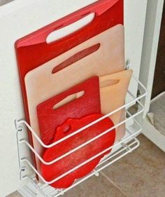 three cutting boards in a metal holder on the wall