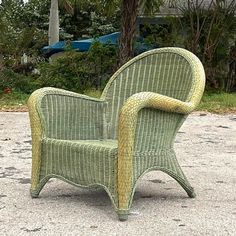 a green wicker chair sitting on top of a cement ground