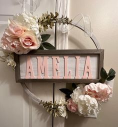 a wooden sign that says ambella with flowers on the front and side of it