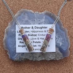 a mother and daughter necklace on a rock