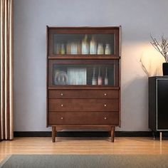 a tall wooden cabinet sitting next to a black television set on top of a hard wood floor