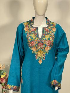 A stunningly marvellous Pheran. This Pheran features intricate Kashmir Aari embroidery on neckline and sleeves.- - - - - - - - - - - - - - - - - - - - Product Details- Condition: Brand New (made to order)- Style: Pheran Tunic with Half Band Collar- Fabric: Pure Wool- Colour: Turquoise- Embroidery: Aari Work- Embroidery Colour: Multi-Colour- Standard Length: 40" | Can be customized- Care Instructions: Dry Clean Only**If you want the Tunic to be shorter or longer, just send us a message, and we wi Pheran Kashmir Women, Half Band Neck Kurti, Band Neck Designs For Kurtis, Embroidered Long Sleeve Kaftan For Diwali, Diwali Embroidered Long Sleeve Kaftan, Long Sleeve Embroidered Kaftan For Diwali, Embroidered Bollywood Style Semi-stitched Kaftan, Traditional Multicolor Kaftan With Embroidered Border, Traditional Semi-stitched Long Sleeve Kaftan