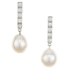 Pearl and diamond dangle earrings. 2 freshwater cultured white pearl drops measuring 11.5mm, each attached to a 14k white gold row of 5 frame set brilliant cut diamonds. Elegant but simple. 10 round brilliant cut diamonds, G-H SI approx. .40cts 2 freshwater white pearl drops, good lustre, silver overtone 11-11.5mm 14k white gold Stamped: 14k 7.3 grams Top to bottom: 33.8mm or 1.33 Inches Width: 16.9mm or .43 Inches Depth or thickness: 11.0mm Please Note, we photograph each item as accurately as Elegant White Bridal Earrings With Single Cut Diamonds, Classic White Gold Pearl Earrings, Classic Formal Diamond Drop Earrings, Classic Pear-shaped Diamond Earrings With Single Cut, Elegant White Single-cut Diamond Earrings, Classic Platinum Pearl Earrings For Formal Occasions, Classic Pear-shaped Platinum Jewelry, Elegant White Earrings With Single Cut Diamonds, Classic Teardrop Platinum Jewelry