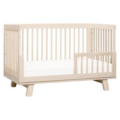 a wooden crib with white sheets on the bottom and side rails, in front of a white background