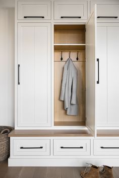 a white closet with two coats hanging on the doors