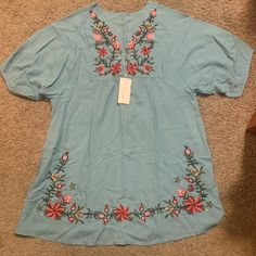 Adorable Top By Futurino. This Is Nwt (New With Tags). Size Medium. Short Sleeves. Three Buttons At The Front Neck. Beautiful Embroidered Flower Detailing. Longer, Roomier Style. Blue Short Sleeve Embroidered Top For Spring, Blue Embroidered Short Sleeve Top For Spring, Blue Embroidered Top With Hem For Spring, Blue Embroidered Top With Hem Detail For Spring, Light Blue Floral Embroidery Tops For Vacation, Blue Embroidered Top With Hem Design For Spring, Blue Blouse With Embroidered Hem For Spring, Blue Cotton Embroidered Top For Vacation, Blue Embroidered Short Sleeve Top For Vacation