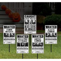 four halloween yard signs in front of a house