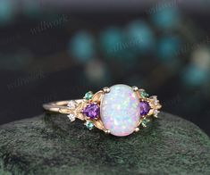 an opal and amethorate ring sitting on top of a rock