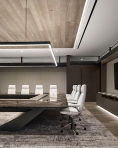 an empty conference room with white chairs and a large wooden table