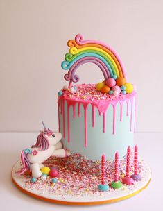 a birthday cake decorated with sprinkles and a unicorn