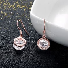 This beautiful style is a perfect gift for any lady or the perfect reason to spoil yourself! Designed in feminine rose gold color, each earring features a sparkling round cut stone paired with a open circle drop that catches and reflects light. All stones glisten with every beat of her heart and every turn of her head. Celebrate your sweetheart with these sweet drop earrings. Weight: 3.6 gWidth: 10 mmHeight: 27 mmMaterial: 925 SilverPlating Color: Rose Gold Elegant Rose Gold Crystal Earrings With Cubic Zirconia, Elegant Rose Gold Crystal Earrings With Sparkling Stones, Elegant Sparkling Rose Gold Earrings, Rose Gold Halo Design Hoop Earrings For Gift, Rose Gold Round Hoop Earrings For Pierced Ears, Rose Gold Hoop Earrings With Halo Design For Gift, Rose Gold Sparkling Drop Earrings, Formal Rose Gold Crystal Earrings For Pierced Ears, Sparkling Rose Gold Round Cut Jewelry