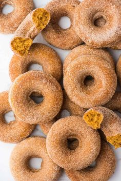 a pile of doughnuts sitting on top of a white table covered in powdered sugar