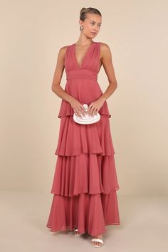 a woman in a red dress holding a white purse and standing on a beige background