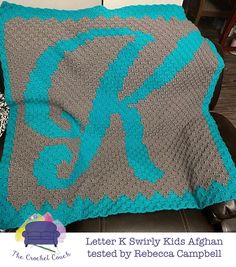 a crocheted blanket sitting on top of a brown chair next to a pillow