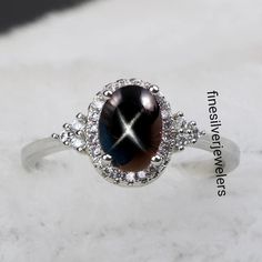 This Ring Features a 6X8 MM Oval Cabochon Natural Black Lindy Star and Sterling Silver Finished with rhodium. Customization is available. It is made by hand, and it will take about 3 to 5 business days to finish the ring after your payment is completed. Product Description Main stone: Natural Black Lindy Star Metal type: 92.5 Sterling Silver finished with rhodium How To take care of This Ring - Keep the jewelry away from direct heat, water, perfumes, deodorants, and other strong chemicals. Wipe Silver Star-shaped Gemstone Ring, Silver Star-shaped Ring With Gemstone, Sapphire Ring Engagement, Black Star Sapphire, Star Sapphire Ring, Star Sapphire, Star Jewelry, Star Ring, Ring Engagement