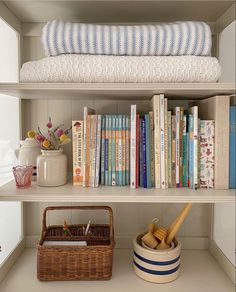 a book shelf with books and baskets on it