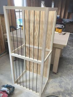 a wooden shelf with metal bars on it in a room that is being built into the wall