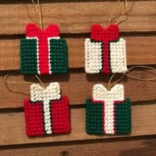 three christmas ornaments hanging from strings on a wooden wall, decorated with bows and ribbons