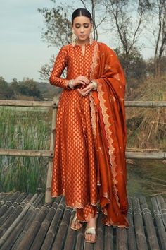 Burnt orange vegan silk anarkali with floral weaving pattern. Comes with pant and a dupatta. - Aza Fashions Luxury Orange Anarkali Set With Zari Work, Luxury Orange Dress For Diwali, Cheap Orange Traditional Wear, Burnt Orange Dress With Blue Accessories, Cheap Anarkali Sets With Zari Weaving, Luxury Slub Silk Anarkali Set For Festive Occasions, Luxury Festive Slub Silk Anarkali Set, Anarkali Silk Suits, Luxury Designer Orange Churidar