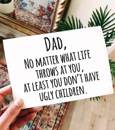 someone holding up a card that says dad no matter what life throws at you, at least you don't have ugly children