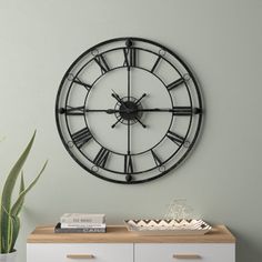 a large clock on the wall above a dresser