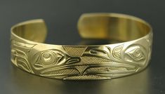 This is a new, hand-engraved, Northwest Coast Native First Nations gold cuff bracelet. Depicting Raven and Frog, this exquisitely carved gold bracelet measures 1/2" x 6" and will fit a wrist between 6 1/4" - 6 3/4" in circumference. It is signed on the inside by Kelvin Thompson and weighs roughly 18 grams solid 14k gold.Raven is often paired with Frog in Native art from the Pacific Northwest because Frog is viewed as the one who communicated Raven's knowledge to the people. These symbols also re Heirloom Style Polished Gold Bangle, Luxury Collectible Yellow Gold Bangle, Luxury Yellow Gold Collectible Bangle, Classic Round Cuff Bracelet For Ceremonial Occasions, Classic Round Ceremonial Cuff Bracelet, Luxury Engraved Bracelets For Ceremonial Occasions, Luxury Engraved Gold Bracelet For Ceremonial Occasions, Classic Ceremonial Cuff Bangle Bracelet, Traditional Jewelry With Engraving Option For Formal Occasions