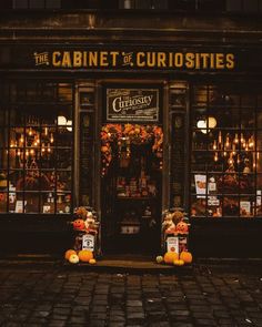 two teddy bears sitting in front of a store with pumpkins on the ground outside