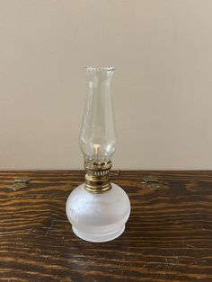 a glass candle holder sitting on top of a wooden table