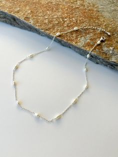 "Dainty Freshwater Pearl and Silver necklace.  Materials:  5x3mm Freshwater Pearls. Sterling silver chain and wire. Sterling silver lobster clasp. Necklace length from 16\" to 30\"+ 3 inches sterling silver extended chain. * Custom orders are welcome. Every once in awhile, you see things that bring you pure joy. Admire this necklace and smile as others do the same when you wear it.  Freshwater pearls are cultured pearls, grown in lakes, rivers, as well as ponds. Most Freshwater pearls are white