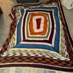 a multicolored blanket sitting on the floor