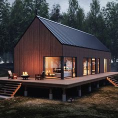 a house with a deck and stairs leading to the front door is lit up at night