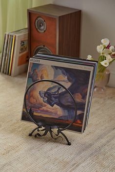 there is a cd holder on the table with an animal painting in front of it