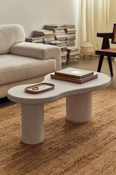 a coffee table sitting on top of a rug in a living room next to a couch