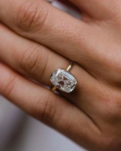 a woman's hand holding an engagement ring with a large white diamond in it