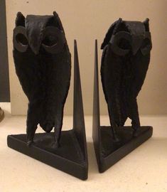 two black bookends sitting on top of a white counter next to each other