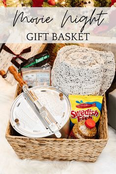 a gift basket filled with cookies, marshmallows and other holiday treats in front of a christmas tree