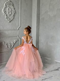 Introducing the Malita Luxury Couture Flower Girl Dress, a masterpiece crafted for those moments that will be cherished forever. This exquisite dress features a satiny bodice that gleams with elegance, paired with a daring plunging V neckline at the back, adding a touch of sophistication and charm. The highlight is a delicate bow that sits gracefully at the back, symbolizing purity and innocence. Cascading to the floor, the full-length tulle skirt creates an ethereal silhouette, making it perfec Lace Birthday Dress, Communion Dresses Lace, Baby Tulle Dress, Flower Girl Dress White, Girl Dress White, Blush Flower Girl Dresses, Girls Communion Dresses, Long Flower Girl Dresses, Satin Flower Girl Dress