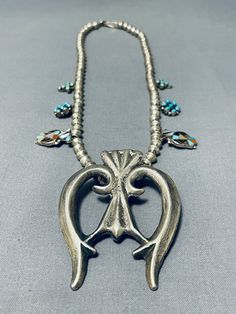 "SQUASH BLOSSOM NECKLACE MAKE US AN OFFER BY CLICKING THE \"MESSAGE SELLER\" Button- This is a marvelous vintage Navajo silver squash blossom necklace that is very rare as the squashes aren't the typical style of squashes you usually see on a squash blossom necklace. This necklace contains inlaid thunderbird pendant, cluster flower shaped pendants and inlaid turquoise cross pattern silver pendants. I just love the detailing of this necklace. Resting at the bottom is a phenomenal thick and sturdy Vintage Blue Turquoise Necklace With Concho, Vintage Concho Necklaces For Festivals, Vintage Concho Necklace For Festival, Vintage Turquoise Concho Necklace, Traditional Turquoise Concho Necklace, Traditional Turquoise Necklace With Concho, Vintage Turquoise Necklace For Festivals, Southwestern Turquoise Necklace, Naja Necklace