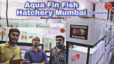 two men standing next to each other in front of a fish hatchery and machine