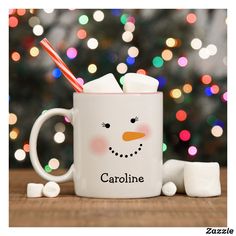 a frosty mug with marshmallows around it and a christmas tree in the background