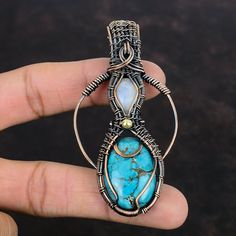 Note : Due to the natural formation of this gemstone. Slight variation in design and color are to be expected. Tibetan Turquoise Copper Pendant Wire Wrapped Gemstone Pendant Rainbow Moonstone Pendant Copper Wire Wrap Jewelry Handmade Pendant For Gifts Handmade Copper Pendant SKU : VFWP-4421 Gemstone : 1: Tibetan Turquoise                       2: Rainbow Moonstone Stone Shape : 1: Oval                           2: Oval Metal Purity : Copper Pendant Length : 80 MM   Pendant Width : 42 MM It is al Bohemian Cabochon Gemstones For Jewelry Making, Handmade Bohemian Moonstone Gemstones, Turquoise Pendant Gemstone, Turquoise Natural Stones Pendant Gemstones, Handmade Moonstone Pendant Gemstone, Turquoise Natural Stone Pendant, Bohemian Aquamarine Jewelry In Turquoise, Bohemian Aquamarine Turquoise Jewelry, Artisan Blue Moonstone Jewelry