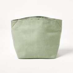 a green bag sitting on top of a white surface