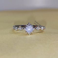 a white diamond ring sitting on top of a wooden table