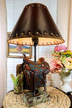 a lamp that is sitting on top of a table next to a vase with flowers