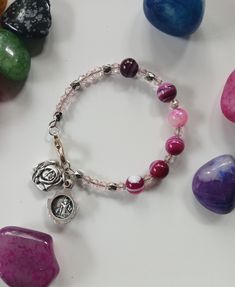 This bangle features a rose shaped locket containing St. Michael and Guardian Angel images. The pink gemstones make up a decade of the Rosary. Guardian Angel Images, Decades Of The Rosary, Rose Locket, Angel Images, Rosary Prayer, Rosary Bracelet, Saint Michel, Pink Gemstones, St Michael