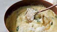 a wooden spoon in a brown bowl filled with food