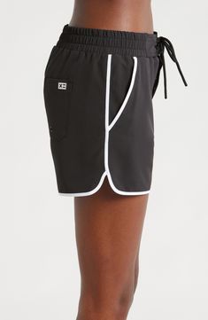 A '90s-inspired lace-up closure and dolphin hem bring some extra fun to these stretchy, high waist board shorts featuring built-in sun protection for the win. 2 1/2" inseam Zip fly with snap closure; lace-up closure Front slant pockets; back patch pocket with drainage grommet UPF 50+ sun protection 92% recycled polyester, 8% spandex Machine wash, tumble dry Imported Summer Activewear With Relaxed Fit And High Waist, Sporty Shorts With Built-in Shorts For Vacation, Black Sports Bottoms For Summer, Black Athletic Shorts With Built-in Shorts For Summer, Sporty Summer Activewear With Drawstring, Black Swimwear With Built-in Shorts, Sporty Black Swimwear With Built-in Shorts, Black Athleisure Bottoms For Summer, Sporty Swim Trunks With Built-in Shorts