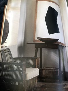 an open book with black and white pictures on it's cover, sitting next to wicker chairs