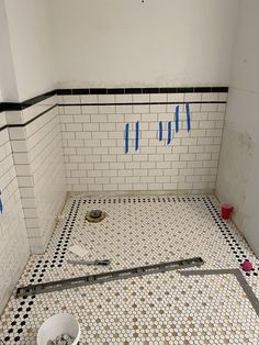 a bathroom that is being remodeled with blue tape on the floor and tile around it