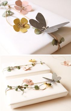 three different types of paper flowers and leaves on a white tablecloth with gold, silver, pink, green